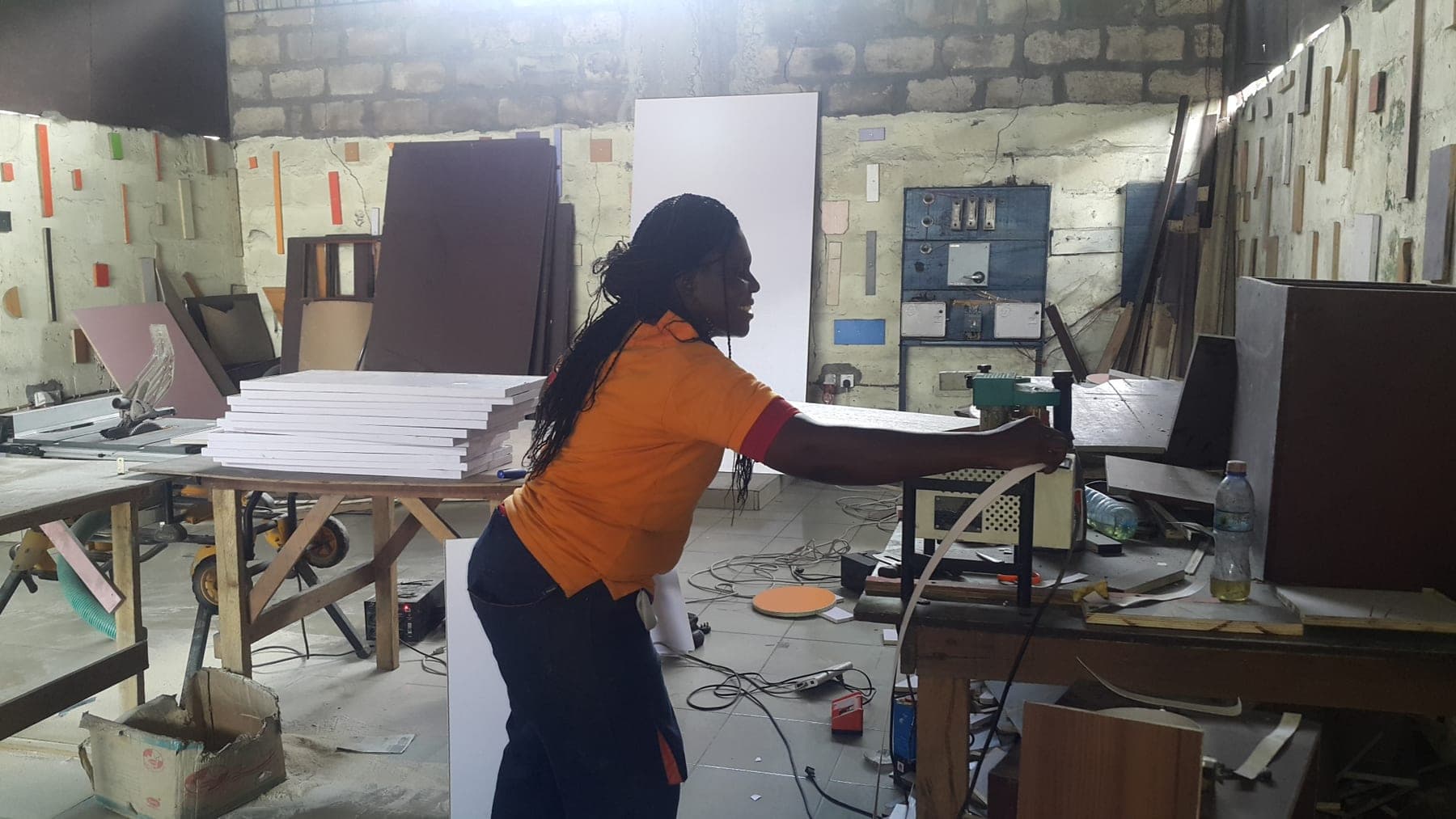 Nigerian woman operating production machinery in her manufacturing workshop